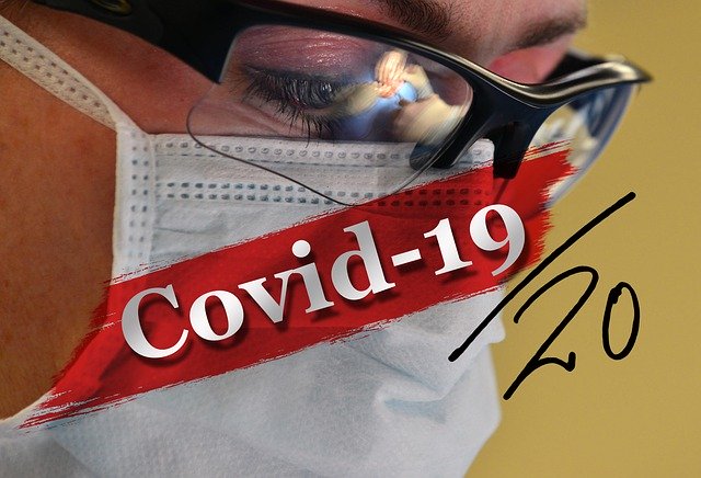 Build an emergency fund -Person wearing face mask with the word Covid-19 across